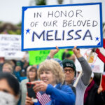 Protester at the No Kings protest in St. Paul, Minnesota on June 14th, 2025. Holding up a sign that reads "In Honor Of Our Beloved Melissa". Referring to Minnesota lawmaker Melissa Hortman who was assassinated hours earlier.