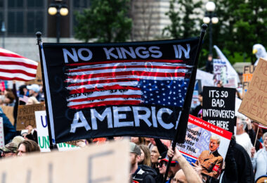 Protester holds up a No Kings in America flag during a June No Kings protest.

Despite warnings from the law enforcement not to attend today’s No Kings rally after this mornings shootings of Minnesota lawmakers with the killer on the lose, the No Kings Rally is happening at the Minnesota State Capitol in St. Paul.