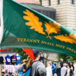 Protester with a Tyranny Shall Not Prevail flag at a No Kings protest.Despite warnings from the law enforcement not to attend today’s No Kings rally after this mornings shootings of Minnesota lawmakers with the killer on the lose, the No Kings Rally is happening at the Minnesota State Capitol in St. Paul.