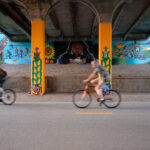 Bikers ride past a new mural on the Midtown Greenway in South Minneapolis.