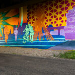 A mural by Cadex and Ethan Herrera created in 2025 on the Midtown Greenway.