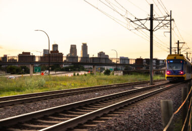 A Metro Transit train heading out of Downtown Minneapolis during a July 2025 sunset.