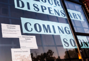 "Our Dispensary Coming Soon" in storefront windows on Hennepin Avenue in Uptown Minneapolis.