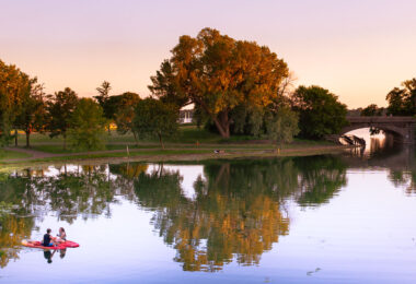 2 paddle boarders meet during sunset on Lake of the Isles in South Minneapolis.