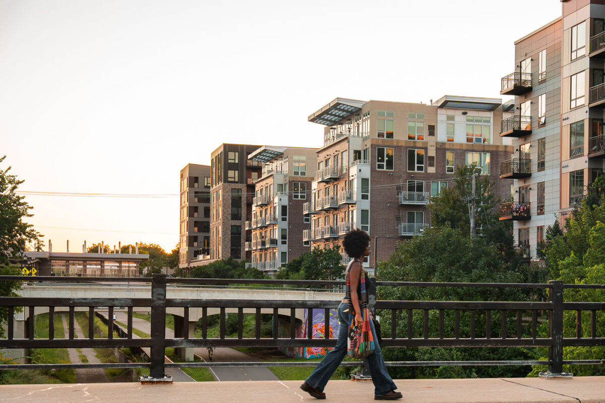 A woman walks over the Emerson Ave bridge in Uptown Minneapolis. The bridge goes over the Midtown Greenway bike trail.