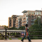A woman walks over the Emerson Ave bridge in Uptown Minneapolis. The bridge goes over the Midtown Greenway bike trail.