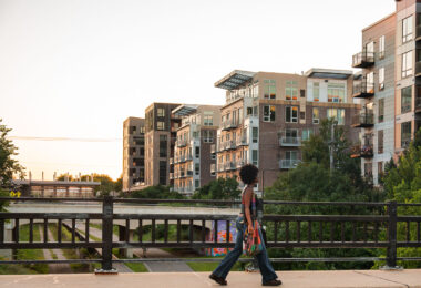 A woman walks over the Emerson Ave bridge in Uptown Minneapolis. The bridge goes over the Midtown Greenway bike trail.