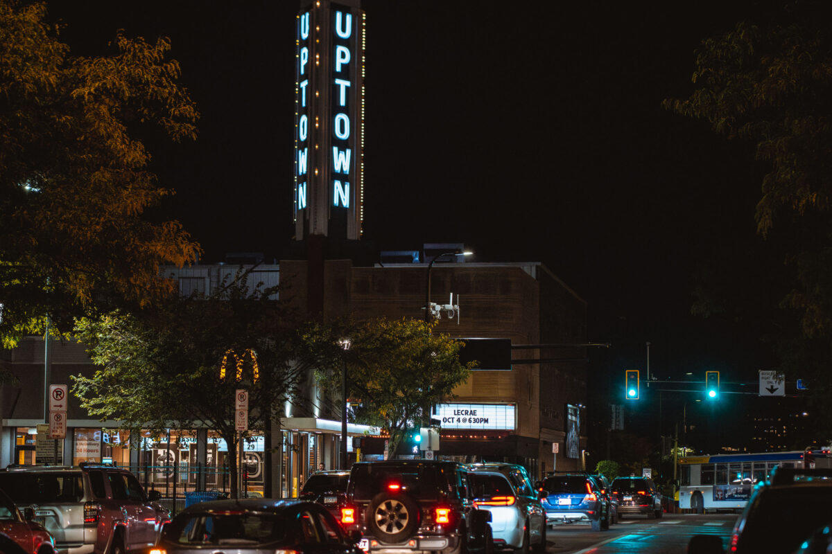 Uptown Theater on Hennepin Avenue in Minneapolis at night, with traffic and a marquee for Lecrae.