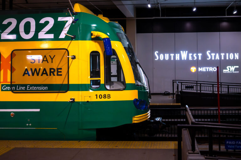 Green Line Extension Train at SouthWest Station 4 A Green Line Extension train is stopped at Southwest Station, indicated by signage. The train is marked with "2027" and "Green Line Extension."