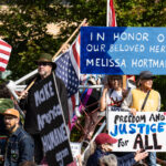 Protesters holding signs that read "In Honor of Our Beloved Hero Melissa Hortman" and "Freedom and Justice For All".Thousands protest in Downtown Minneapolis on Saturday October 18, 2025 as part of nationwide “No Kings!” protest.