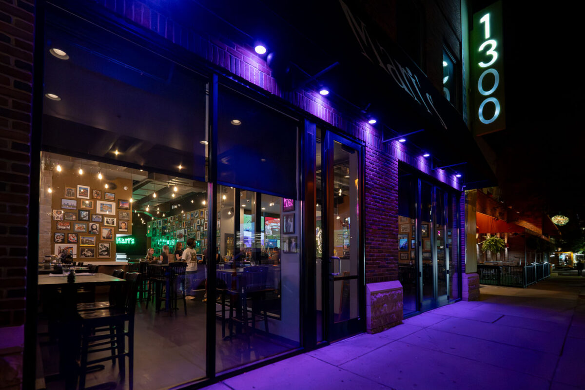 Mary’s bar and restaurant in Uptown at night, with purple exterior lights and diners visible inside.