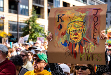 Woman holds up a sign at No Kings Minneapolis.

Thousands protest in Downtown Minneapolis on Saturday October 18, 2025 as part of nationwide “No Kings!” protest. Organizers say 100,000 attended.