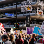 Banners hanging from a parking garage reading "NO KINGS TWIN CITIES" and "WE THE PEOPLE".Thousands protest in Downtown Minneapolis on Saturday October 18, 2025 as part of nationwide “No Kings!” protest.
