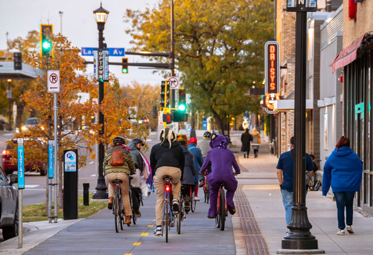 Bikers and Walkers on Hennepin Ave in 2025 2 Cars, cars parked, bikers, walkers on the new Hennepin Avenue in Uptown Minneapolis.
