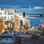 Traffic flows through the LynLake district of Minneapolis at South Dupont and Bryant Avenue, a neighborhood long known as a crossroads between Uptown and Whittier. Once a streetcar junction for the Twin City Rapid Transit Company, the area declined after the 1950s but later rebounded through waves of redevelopment and independent business growth. Today, LynLake blends historic brick storefronts with modern apartments and restaurants, reflecting Minneapolis’s broader push toward urban density and transit-oriented design along the former streetcar corridor.