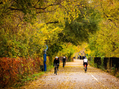 Bikers bike through a colorful Midtown Greenway