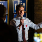 Minneapolis Mayor Jacob Frey speaks to supporters during his 2025 election night gathering, held at a downtown venue adorned with campaign posters. Frey, seeking reelection in the aftermath of years of national attention on Minneapolis politics, reflected on civic challenges and vowed continued focus on rebuilding trust and progress following the city’s social and economic transformation since 2020.