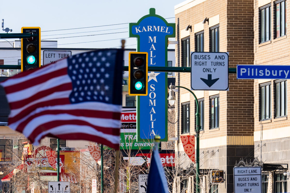 Protester with an American flag outside the Karmel Mall, a Somali shopping center.Thousands marched down Lake Street on a day with windchills struggling to reach 0F.