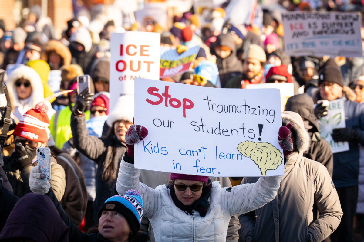 Protester at a protest against the actions of ICE in Minneapolis holds up a sign that reads "Stop traumatizing our students! Kids can't learn in fear."The protest took place on a day with near below 0F windchills.