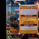 Everyone Is Welcome Here — Except ICE 3 Two printed notices are taped to the front window of a neighborhood business in late December 2025, stating “Private Property — No ICE or CBP Access” and “Everyone Is Welcome Here! Except I.C.E.” The signs outline specific legal language, asserting the right to deny entry to federal immigration authorities without a valid judicial warrant and rejecting the use of administrative warrants.