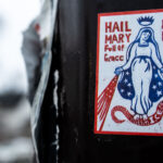 Kick ICE Out Of This Place Sticker 2 Protest sticker on a street pole in South Minneapolis. It reads "Hail Mary Full of Grace Kick I.C.E. Out Of This Place".This at a time when Federal agents are in Minneapolis performing what they call immigration arrests.