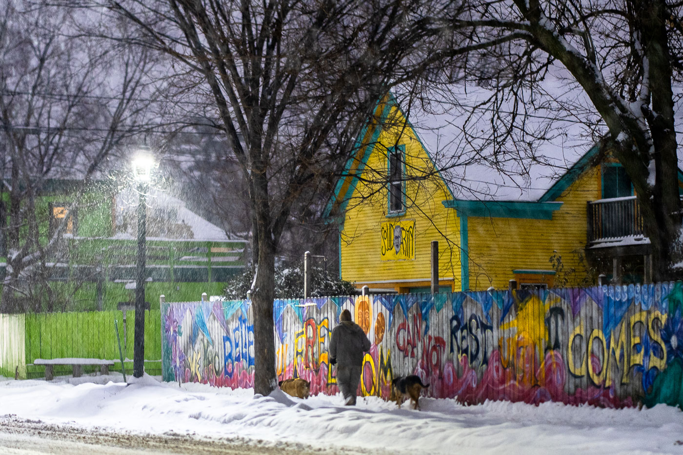 Mural on a Minneapolis fence during snowfall
