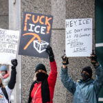 Anti ICE Protest Signs, Minneapolis 2026 2 Protesters at a Jake Lang counter protest in Downtown Minneapolis on January 17, 2026. Signs read:ICE:NUREMBERG TRIALS ARE COMINGTHERE WILL BE CONSEQUENCESFUCK ICE!HEY, ICE!WE DON’T NEED AN MN GOODBYEJUST FUCKING LEAVE!