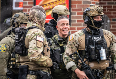 Border Commander Greg Bovino stands outside a South Minneapolis gas station this morning with BORTAC officers in what seemed like an effort to draw more and more people to the scene as other agents shoot high resolution video of the crowd yelling and blowing whistles.