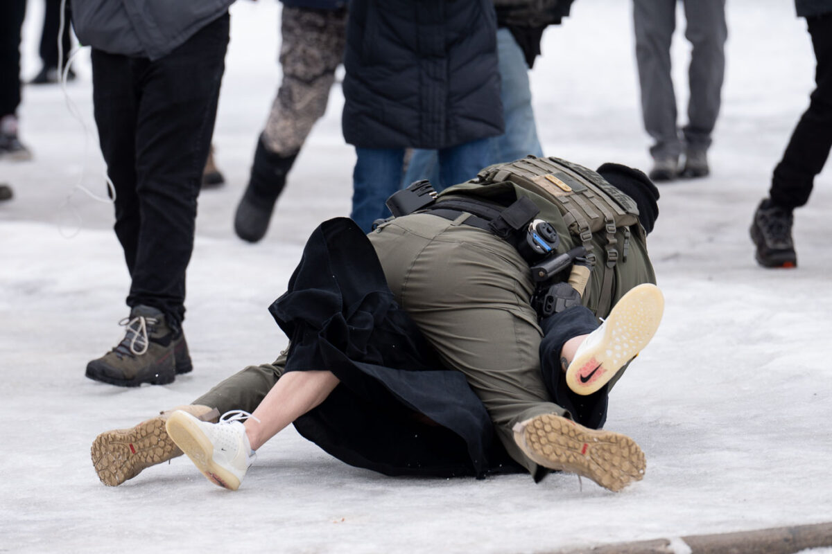 A protester is arrested outside the Whipple Federal Building outside Minneapolis.Protests have gathered outside the fenced in building as hundreds of agents stand outside the fence.