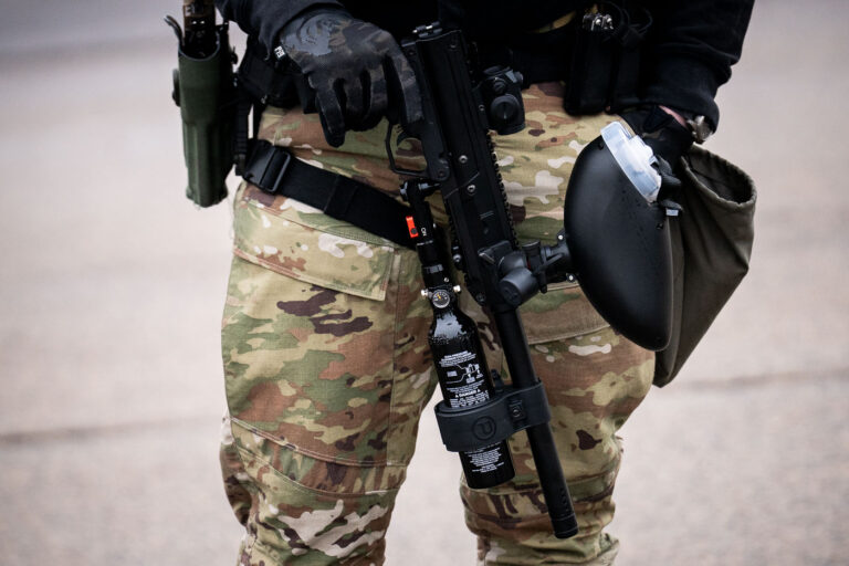 Border Patrol Less Lethal Weapon, Minneapolis 1 A Border Patrol officer stands outside the Whipple building near Minneapolis with a less lethal weapon.