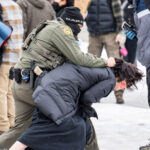 Border Patrol Officer Tackles Protester, Minneapolis 3 A protester is arrested outside the Whipple Federal Building outside Minneapolis.Protests have gathered outside the fenced in building as hundreds of agents stand outside the fence.