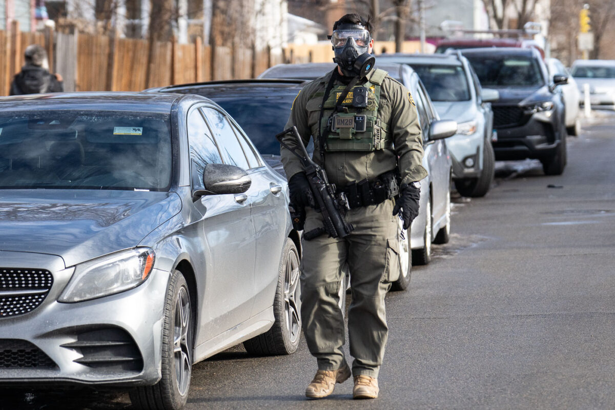 Border Patrol officer with gas mask on neighborhood street