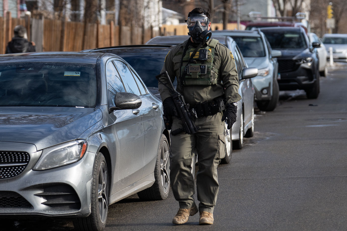 Border Patrol officer with gas mask on neighborhood street