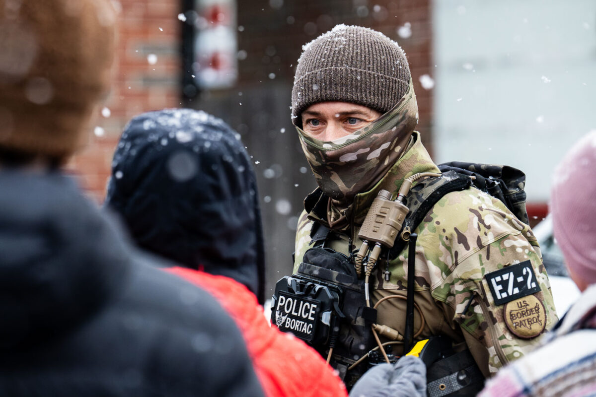 A BORTAC Border Patrol officer interacts with an observer at a Speedway gas station in the morning of January 21, 2026 in Minneapolis.
