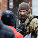 BORTAC officer looks at observer, Minneapolis 1 A BORTAC Border Patrol officer interacts with an observer at a Speedway gas station in the morning of January 21, 2026 in Minneapolis.