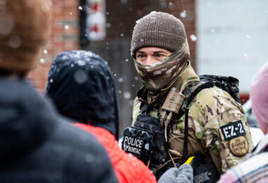A BORTAC Border Patrol officer interacts with an observer at a Speedway gas station in the morning of January 21, 2026 in Minneapolis.