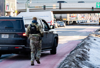 BORTAC officer runs back to a vehicle on Lake Street in Minneapolis on January 14, 2026.