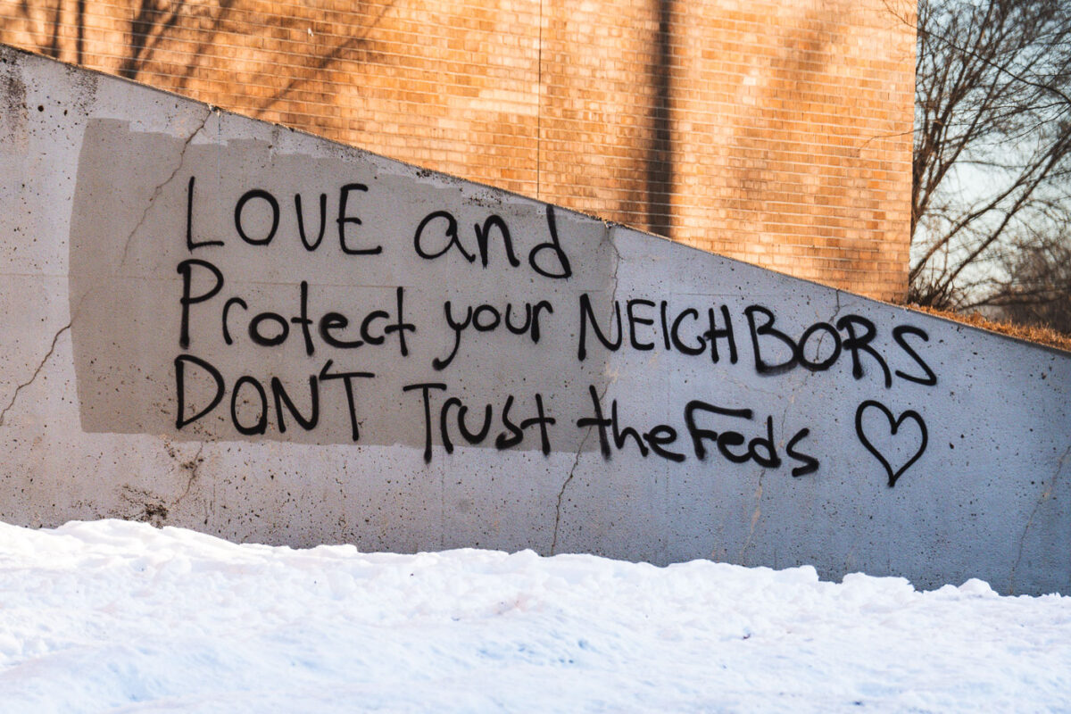 Graffiti on a Minneapolis Public School entrance area that reads "Love and protect your neighbors don't trust the feds"
