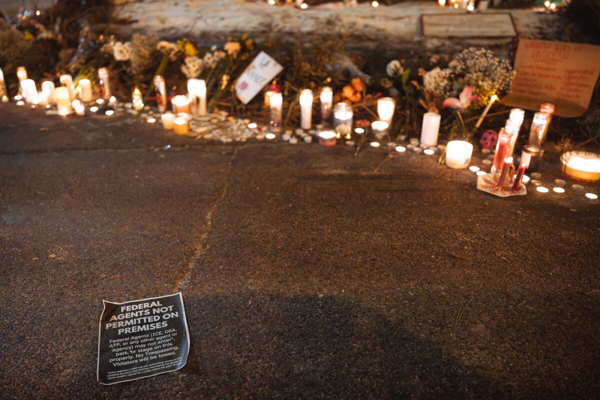 A sign on the ground outside the Alex Pretti Memorial that reads: "Federal agents (ICE, DEA, ATF, or any other agent or agency) may not enter, park, or stage on this property. No trespassing. Violators will be prosecuted."