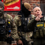 Greg Bovino Points at Observer in Minneapolis 3 Greg Bovino points at an observer in Minneapolis as he stands with the Border Patrol BORTAC unit outside a South Minneapolis gas station on January 21, 2026.