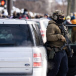 Armed Ice Agent in Minneapolis after shooting 3 Portland Avenue and 34th Street in South Minneapolis where City of Minneapolis officials have confirmed an ICE agent shot an observer.A neighbor who saw what happened told local MPR news: "She was trying to turn around, and the ICE agent was in front of her car, and he pulled out a gun and put it right in — like, his midriff was on her bumper — and he reached across the hood of the car and shot her in the face like three, four times,”