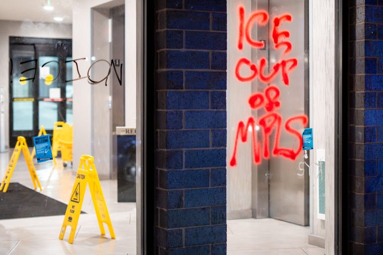 Graffiti on Home2 Suites in Minneapolis Regarding ICE 2 Graffiti reading "ICE CUP OF MPLS" in red spray paint on the glass entrance of Home2 Suites in Minneapolis.
