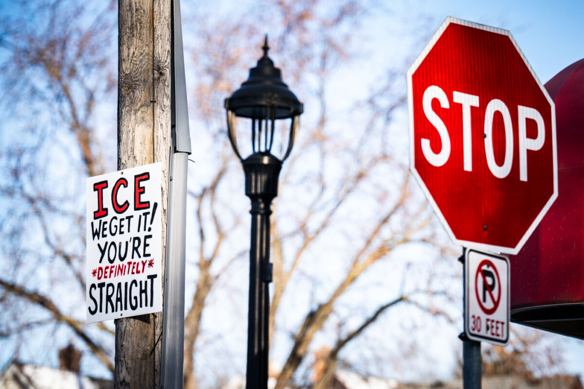 A sign up high on a utility pole that reads "ICE WE GET IT! YOU'RE DEFINITELY STRAIGHT".