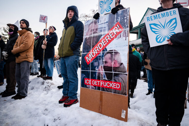 Minneapolis Protest: ICE Agent Murderer Sign 4 Protesters in Minneapolis hold a sign reading "MURDERER! ICE GET FUCKED" and "REMEMBER" with a butterfly graphic.