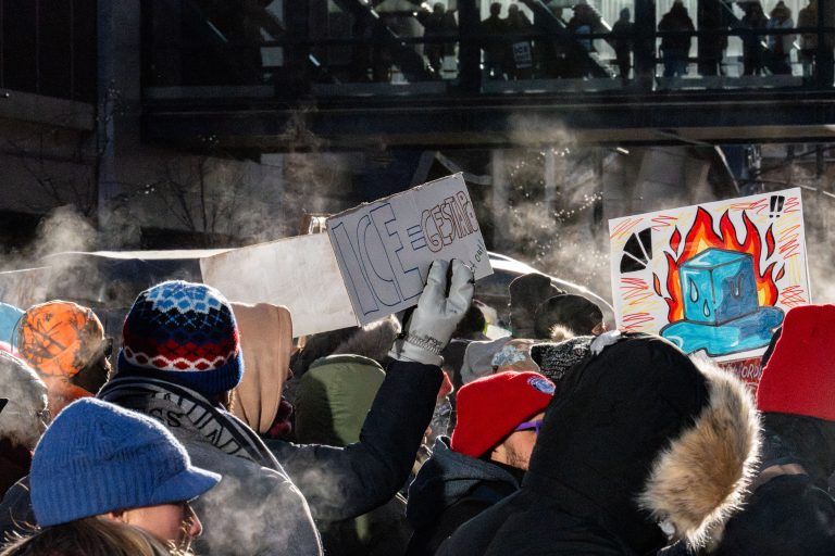 Minneapolis Protest Against ICE Tactics, Jan 2026 4 Protesters in Minneapolis hold signs opposing ICE tactics during a frigid January 2026 march.