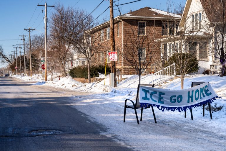 Minneapolis Residents Protest ICE with 'Go Home' Banner 4 A banner reading "ICE GO HOME" is displayed on chairs along a snow-covered street in Minneapolis.