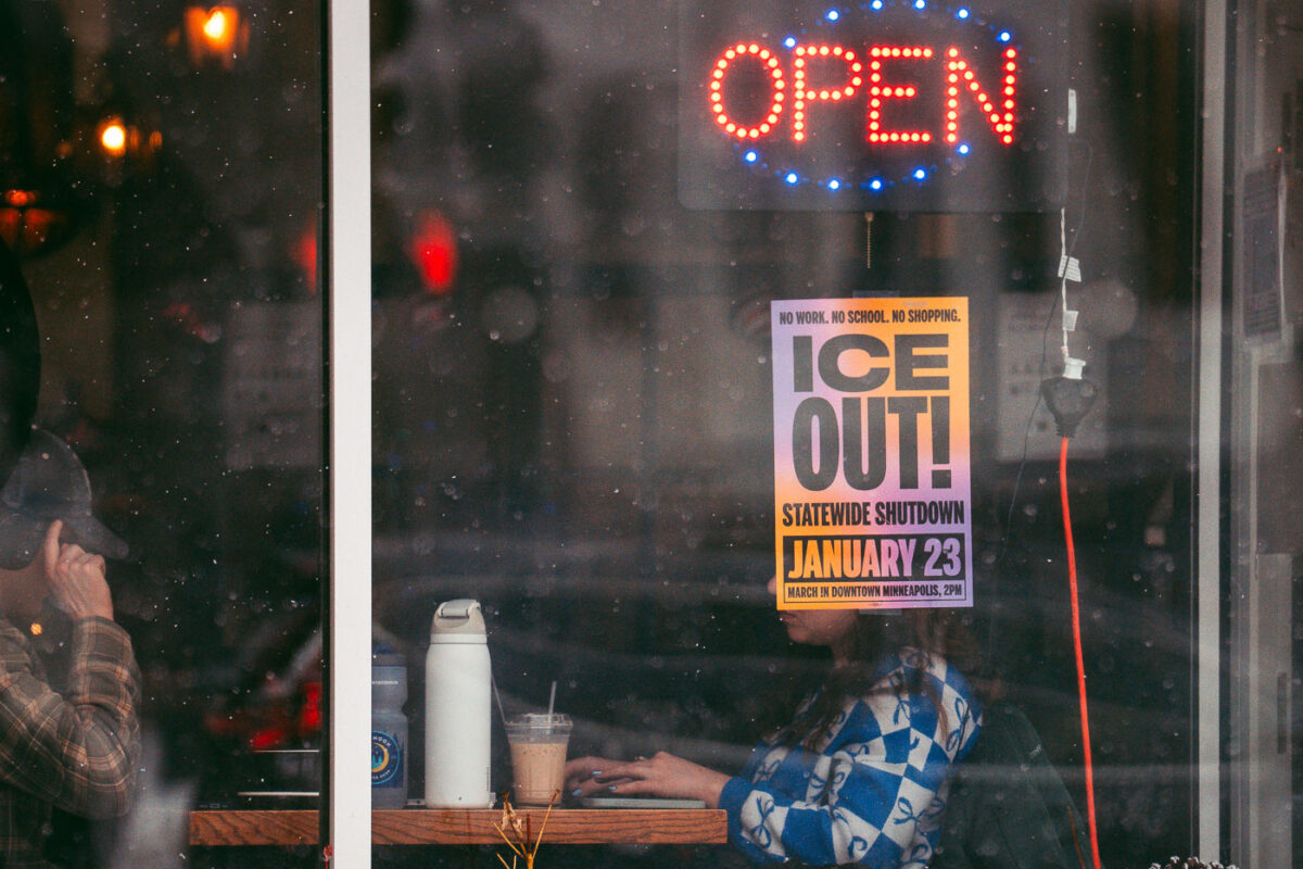 A ICE OUT! Statewide Shutdown sign on a coffee shop window in Minneapolis.