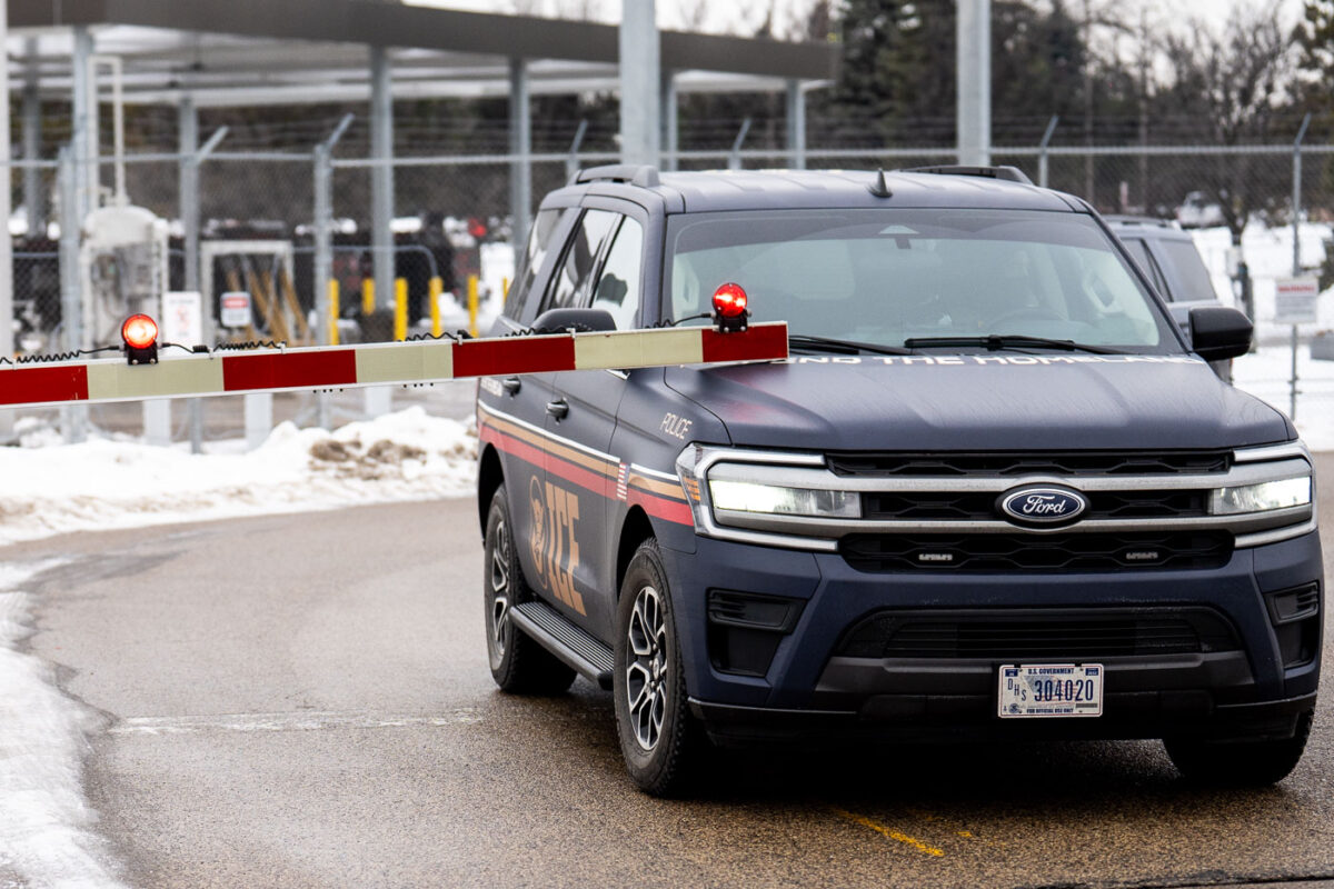 An ICE Vehicle parks too far up and the light rail crossing guards lower onto his vehicle in Minneapolis on January 8, 2026.