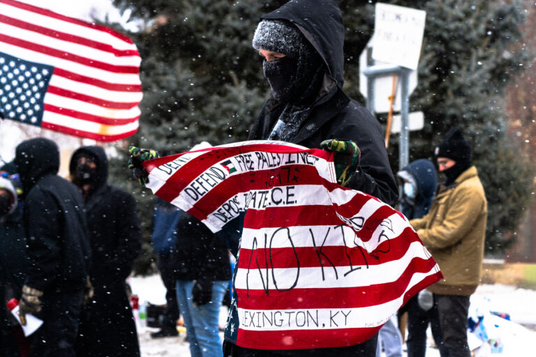 Lexington KY protester in Minneapolis, ANTI ICE Protest 1 Protester outside the Whipple federal building near Minneapolis. The building is being used as an ICE detention.Flag reads:DENY.DEFEND.DEPOSE.ACTA NON VERBAFREE PALESTINELIQUIDATE I.C.E.FIRSTFOOTFORWARDNO KINGS
LEXINGTON, KY