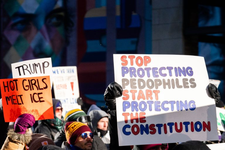 Minneapolis Protest: Hot Girls Melt Ice, Stop Protecting Pedophiles 3 Protesters hold signs in downtown Minneapolis during a march against federal agents and Trump administration policies.